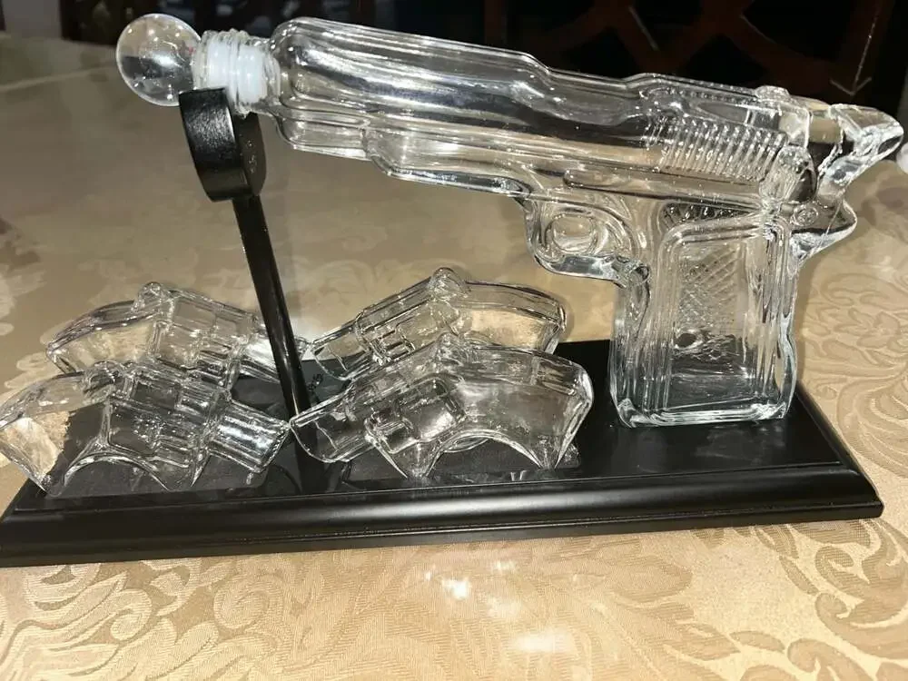 Clear Glass Pistol Decanter Set with Four Glass Shot Glasses on Display Stand
